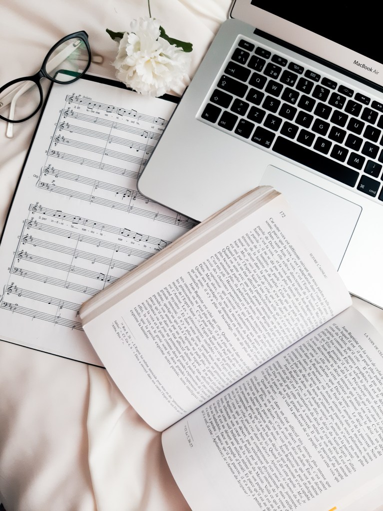Working with quality. Flatlay macbook air and religious music.
